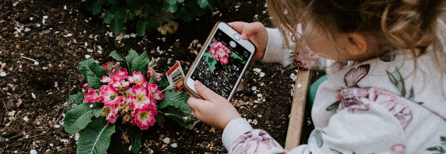 Child using a phone to take a picture in the EYFS